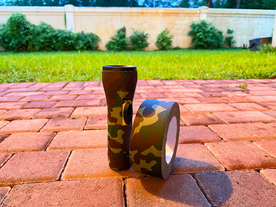 view of a backyard and a roll of camo duct tape used to wrap a camping flashlight