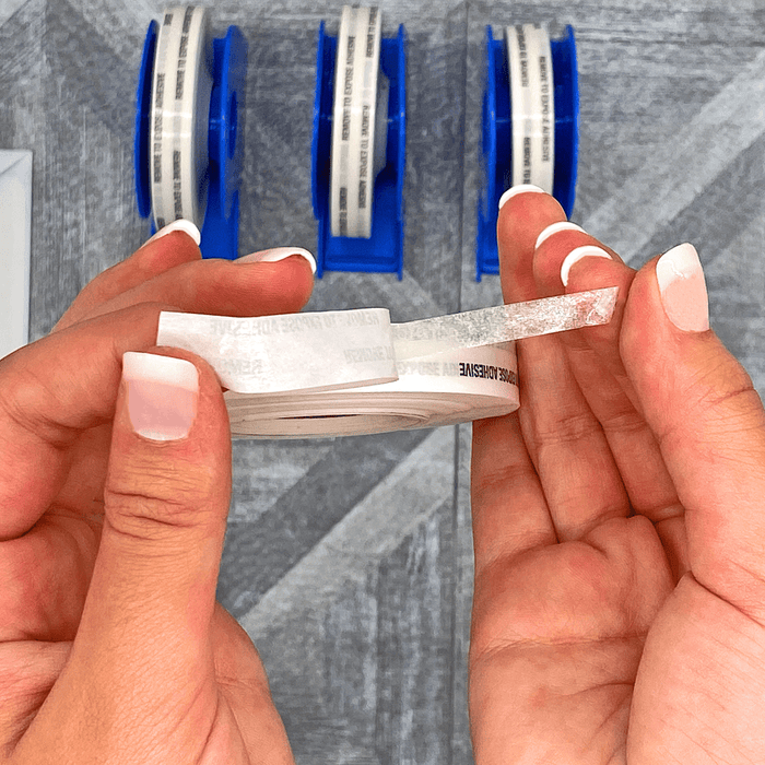double sided tissue tape being pulled from adhesive backing