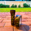 view of a backyard and a roll of camo duct tape used to wrap a camping flashlight