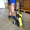 Individual using Floor Tape Dispenser tool loaded with hazard colored tape to apply caution tape on floor