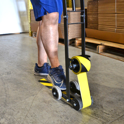 Individual using Floor Tape Dispenser tool loaded with hazard colored tape to apply caution tape on floor