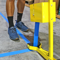 lane marking applicator for floor tape being used to install blue marking tape on pavement