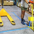 floor tape applicator being used to apply hazard safety tape on floor