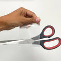duct tape clear with scissors stuck to it to show its heavy adhesion properties