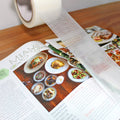 clear waterproof duct tape being used to fix ripped page of a book
