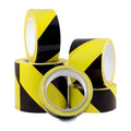 4 rolls of black and yellow safety tape of different widths stacked upon each other