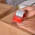 Man deonstrating use of Crystal Clear Carton Sealing Tape with Dispenser on a brown shipping box