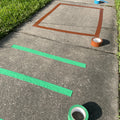 Shapes and stripes made with colored floor marking tape applied on concrete sidewalk 