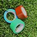 Three rolls each of different colors and sizes  floor marking vinyl tape on grass