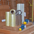 Shipping boxes in bulk below bundle of 4 Rolls of plastic Stretch Wrap  rolls  brown or clear Packaging Tape with 2 Dispensers for Packaging Tape 